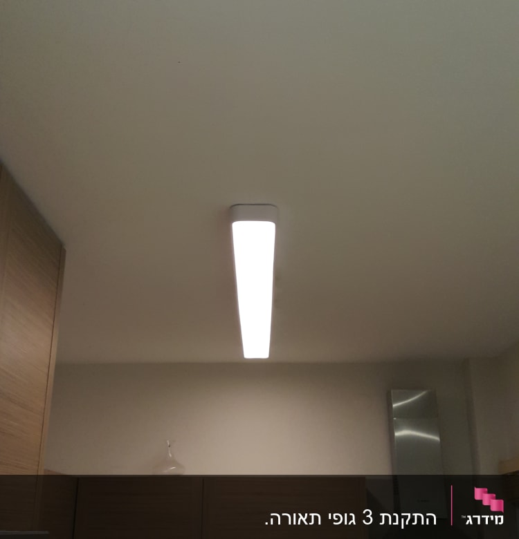 מנורת תקרה מוארת במטבח מודרני